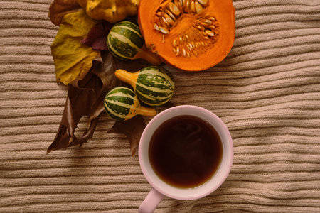 Cup hot tea on the gray table with pumpkin, leaves, spices on the background. Autumn concept. Top view. High quality footageの写真素材