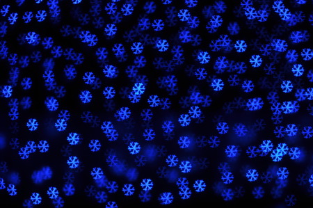 Beautiful holiday background with blue snowflakes defocused lightsの写真素材