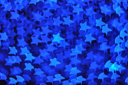 Beautiful holiday background with blue stars defocused lightsの写真素材