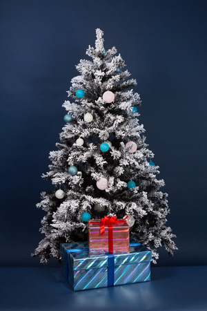 New year tree decoration on dark blue with gift boxesの写真素材