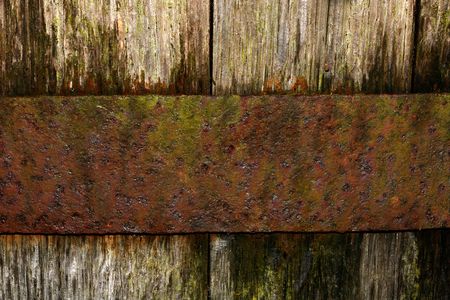Section of an old oak barrel, with a rusty band of metal holding the oak boards in place.の写真素材