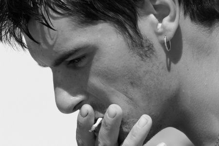 Profile of a man smoking a cigarette. In monochrome.の写真素材