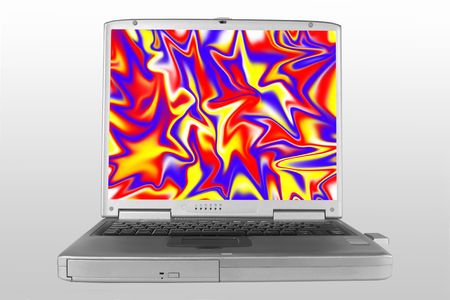 Silver laptop on a gradient grey background with a brightly primary colored abstract on the open screen.の写真素材