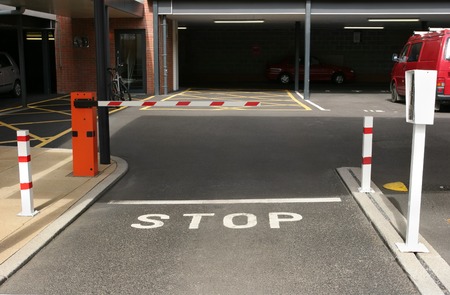 Entrance to an underground car park with gated barrier and entry machine.の写真素材
