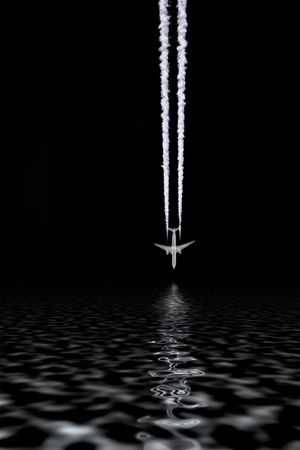 Abstract of a jet aircraft with smoke trails, flying in a vertical direction into water, with reflection, as if about to crash. Set against a black background.の写真素材
