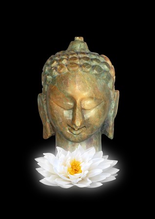 Golden jade buddha head with a glowing white lotus lily flower, isolated over black background.の写真素材