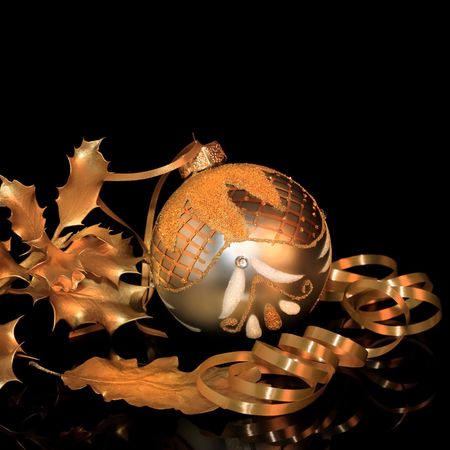 Christmas silver and gold sparkling bauble with golden holly and oak leaf sprigs with ribbon, over black background with reflection.の写真素材