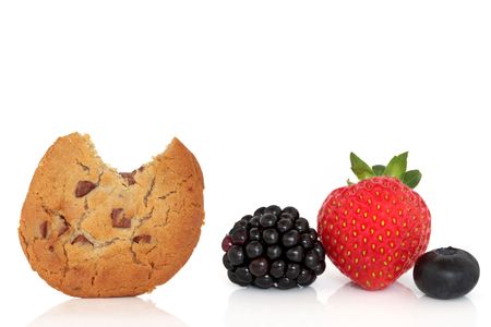 Chocolate chip cookie with a bite taken out and blackberry, strawberry and blueberry fruit isolated over white background with reflection.の写真素材
