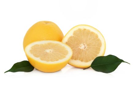 Grapefruit in half and whole, with leaf sprigs, isolated over white background.の写真素材
