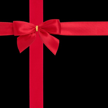 Red satin ribbon with bow isolated over black background.の写真素材