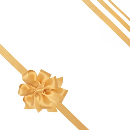Gold satin ribbons with bow isolated over white background.の写真素材