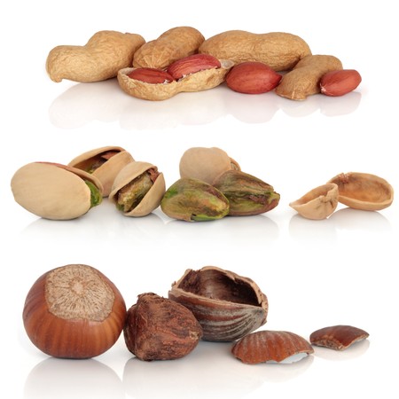 Hazelnut, peanut and pistachio nut collection, isolated over white background with reflection.の写真素材