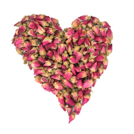Rosebud flowers in the shape of a heart isolated over white background.の写真素材