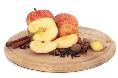  Apple fruit with cinnamon sticks, ginger root, cloves and nutmeg spice on a wooden board, isolated over white background. Gala variety.の写真素材