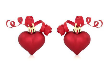 Christmas heart shaped red baubles with ribbons, isolated over white background.の写真素材