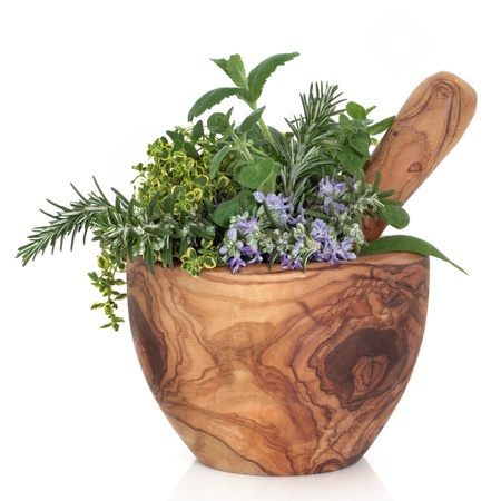  Herb leaf selection of golden thyme, oregano, purple sage, mint and  rosemary in flower in a rustic olive wood mortar with pestle, isolated over white background.の写真素材
