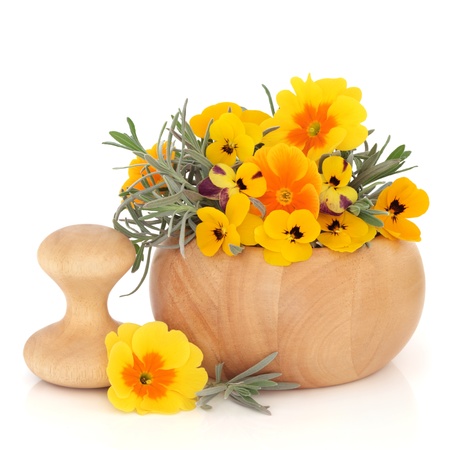  Skincare flora of lavender herb leaf sprigs and viola flowers in a beech wood mortar with pestle and scattered, isolated over white background.の写真素材