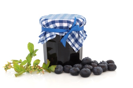 Blueberry jam and flower leaf sprig with loose blueberries, isolated over white background.の写真素材