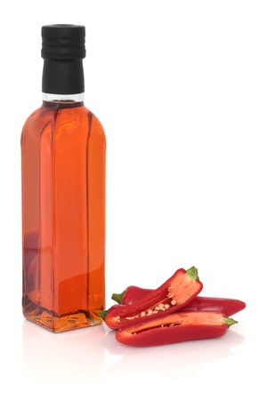  Red chilli pepper olive oil with loose chillies, isolated over white background.の写真素材