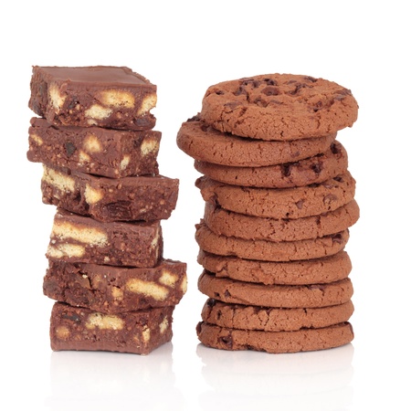 Brownie cakes and chocolate chip cookies in two stacks over white background.の写真素材