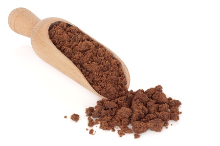 Muscovado sugar in a wooden scoop and loose, over white background.の写真素材