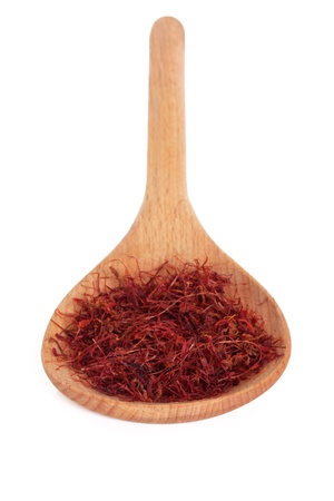 Saffron spice in a wooden spoon over white background. Selective focus.の写真素材