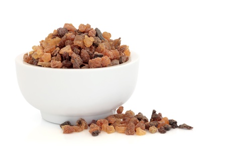 Myrrh oleo gum resin in a porcelain mortar and scattered, over white background.の写真素材