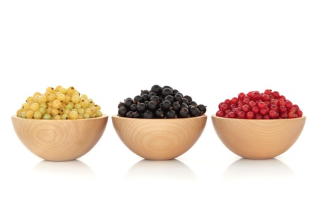  Redcurrant, blackcurrant, white currant fruit in three beech wood bowls, isolated over white background.の写真素材