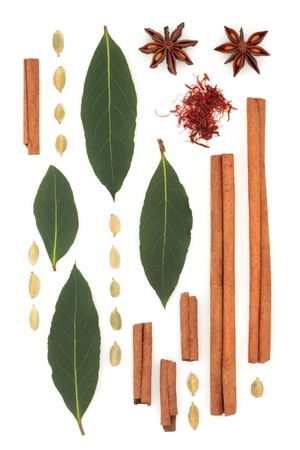 Spice and herb abstract design of saffron, cinnamon sticks, star anise, bay leaf and cardamom pods, over white background.の写真素材