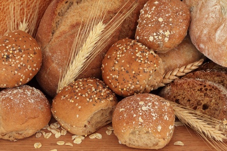 Bread loaf rustic selection of olive, rye ,soda, tiger bloomer breads, with brown granary and oated rolls and ears of wheat.の写真素材