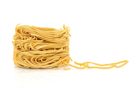 Egg noodles with noodle strands to the side, isolated over white backgroundの写真素材