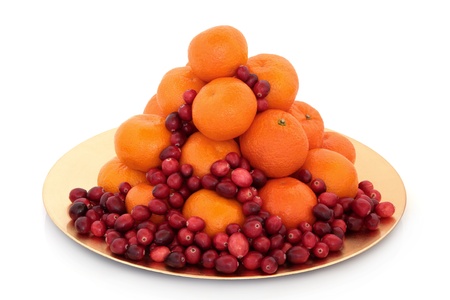 Cranberry and mandarin christmas fruit arrangement on a gold plate isolated over white background.の写真素材