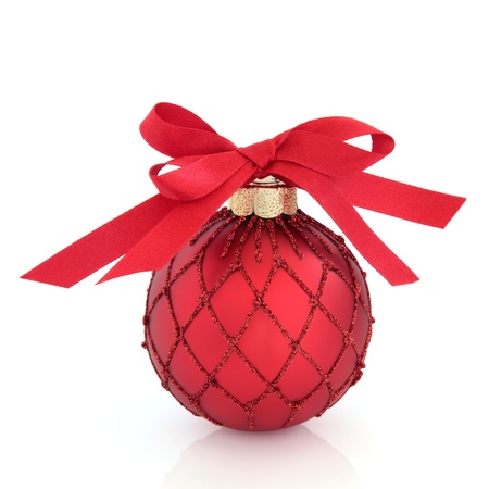 Christmas ball decoration in red with glitter design and bow, isolated over white background.の写真素材