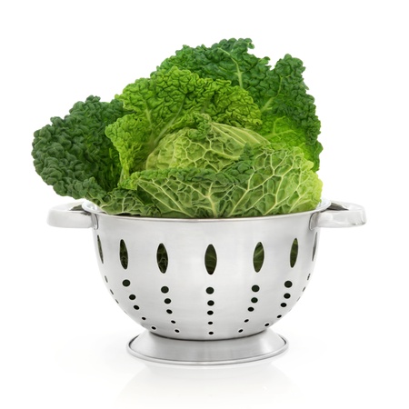 Savoy cabbage in a stainless steel colander isolated over white background.の写真素材