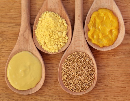  Mustard selection of dijon, powder, seeds and english in wooden spoons over oak background.の写真素材