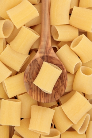 Paccheri rigati neapolitan pasta in an olive wood spoon and forming a background の写真素材