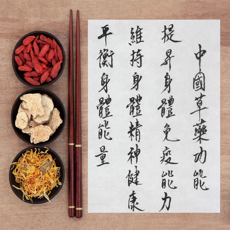 Chinese herbal medicine with mandarin calligraphy script on rice paper over papyrus describing the medicinal functions to maintain body and spirit health and balance energy の写真素材