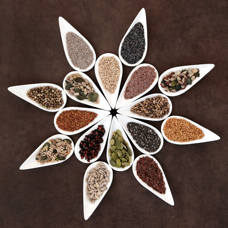 Large seed food selection in porcelain dishes over lokta paper background の写真素材