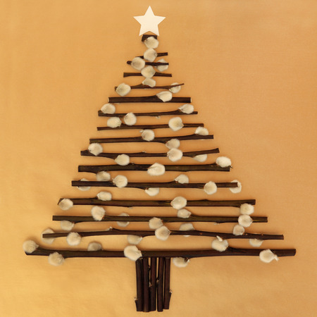 Abstract christmas tree design with pussy willow twigs and star over gold paper background.の写真素材