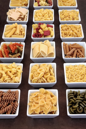 Pasta dried food varieties in white square porcelain bowlsの写真素材