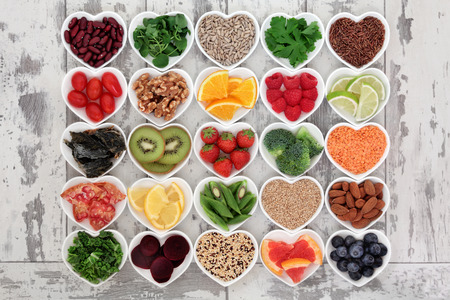 Diet detox super food selection in heart shaped porcelain bowls over distressed wooden background. Diet detox super food selection in heart shaped porcelain bowls over distressed wooden background.