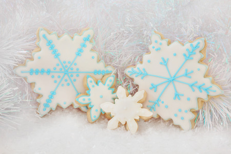 Christmas gingerbread snowflake biscuits over snow and decorative background.の写真素材