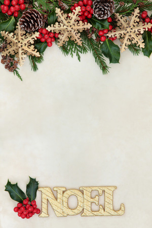 Christmas and noel background border with gold glitter sign and snowflake bauble decorations, holly, fir and cedar cypress greenery on parchment paper.の写真素材