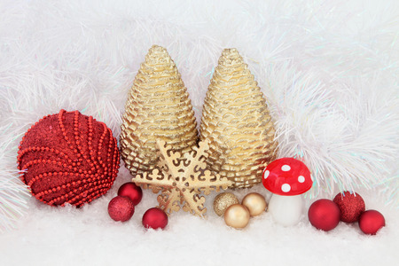 Christmas bauble decorations on snow with decorative tinsel  background.の写真素材