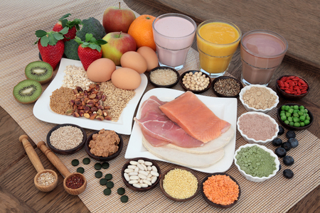 Health and body building food with fish and meat, supplement powders, vitamin tablets, pulses, nuts, vegetables, fruit and high protein and juice smoothie shakes.