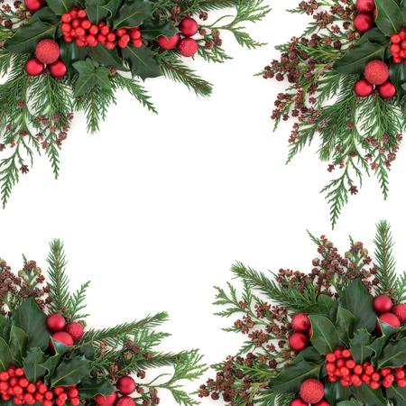 Christmas and winter flora with red bauble decorations, holly, ivy, fir and cedar cypress over white background.の写真素材