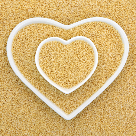 Couscous in heart shaped bowls forming an abstract background.の写真素材