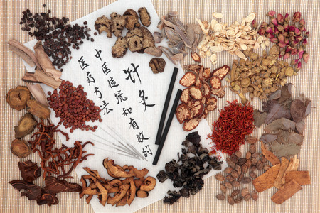 Chinese medicinal herb ingredients, acupuncture needles and moxa sticks  with calligraphy on rice paper. Translation describes acupuncture chinese medicine as a traditional and effective medical solution.の写真素材