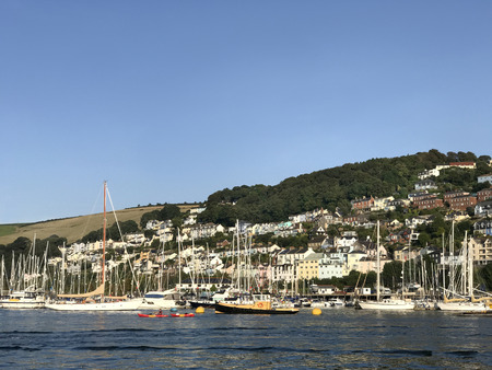 Dartmouth, Devon, UK. August 28th 2017. View of Dartmouth harbor with sailing and speed boats on the river Dart with hillside homes in Darthaven town overlooking the bay area with a blue sky on a summers day to the rear.のeditorial素材