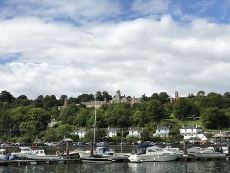 Dartmouth, Devon, 30th August 2017 UK. Dartmouth Royal Britannia Naval College on a hillside, an english officer military training establishment, with pleasure cruisers and sailing boats on the River Dart in the foreground.のeditorial素材